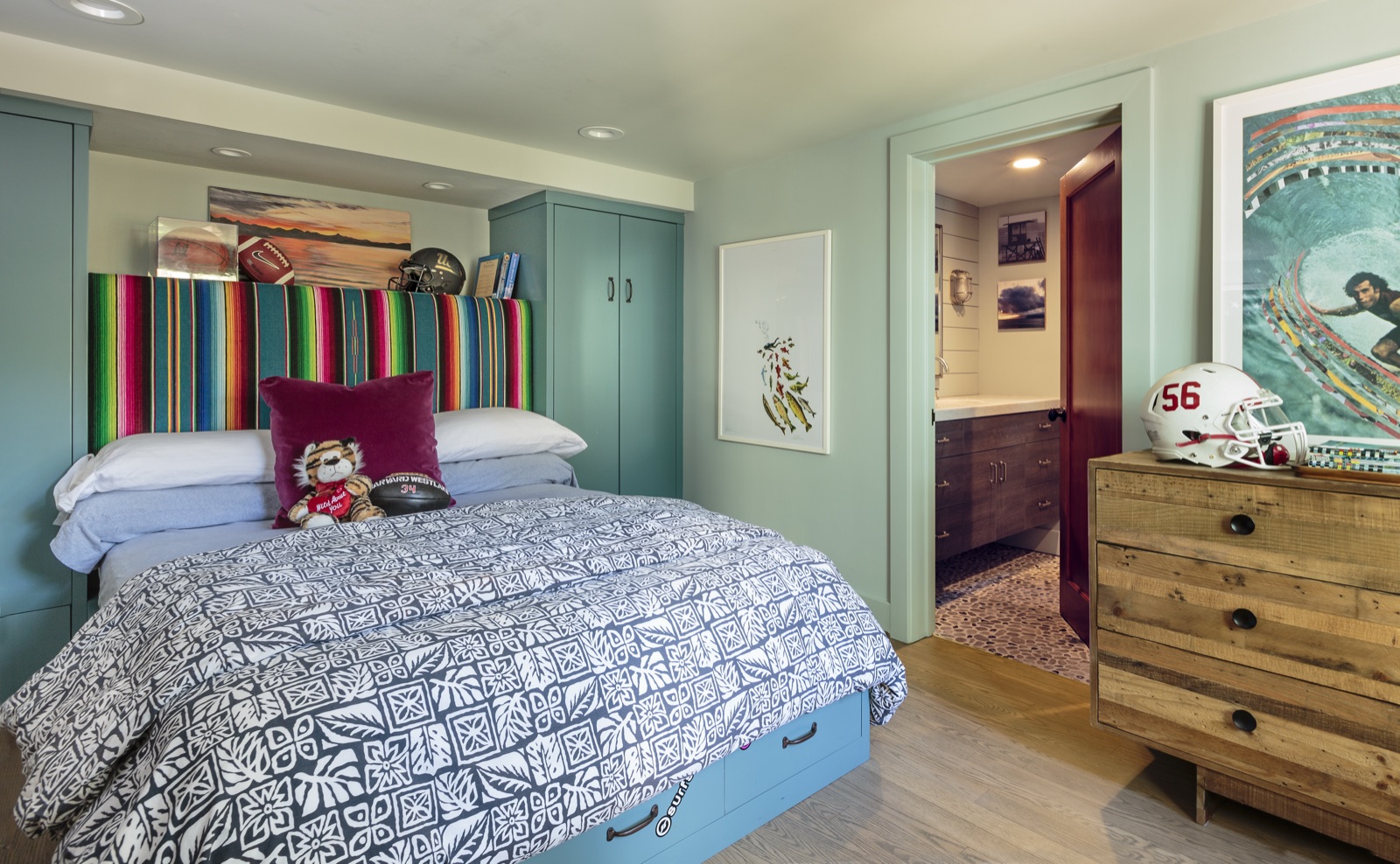 Guest bedroom with floor-to-ceiling custom teal millwork, integrated wardrobe doors and built-in bed, en-suite bath beyond. Brentwood Layton Drive residence by ESRL Development.
