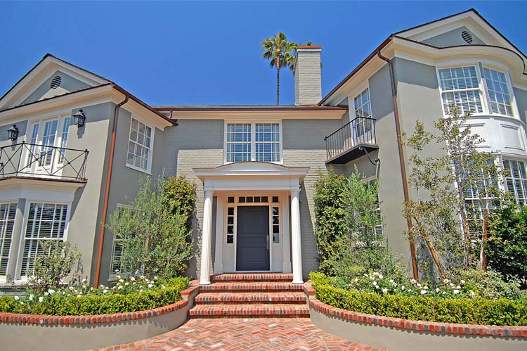 Hollywood Hills custom residence by ESRL Development, hero view of the symmetric front facade with custom stucco exterior, brick stairs, bay window wings, hand-laid brick walkway.